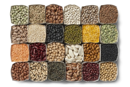 A variety of dried beans and lentils in bags on white background